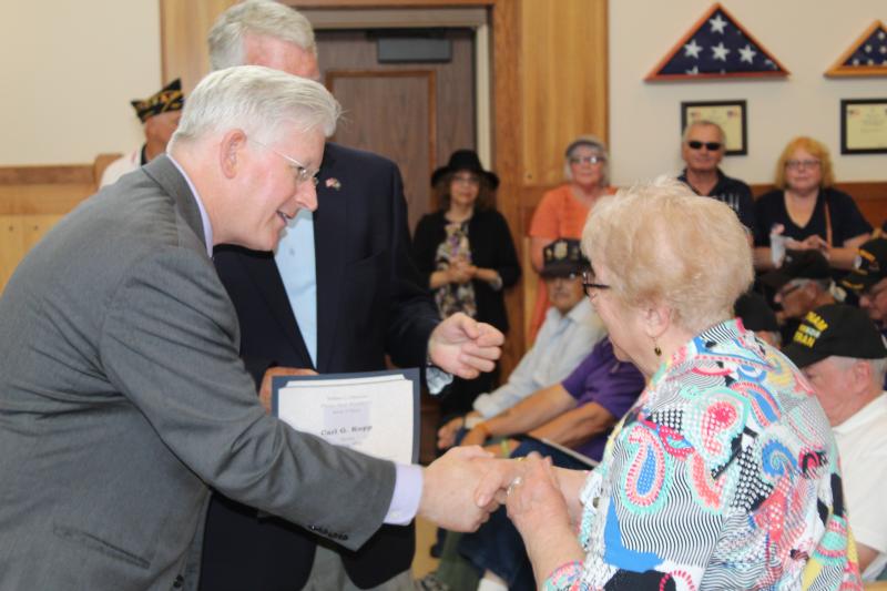 Clerk Kearns presenting a certificate to family member of deceased Purple Heart veteran.